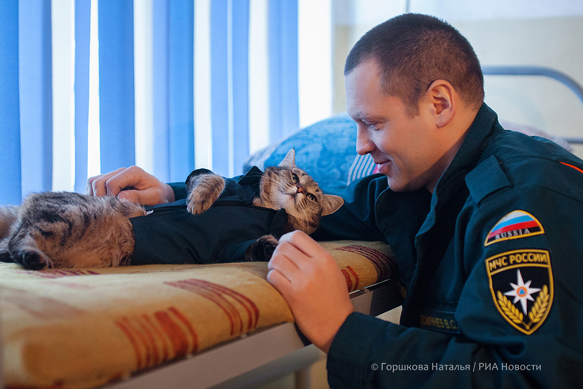 22.01.2022. Виталий Домрачев (начальник караула 135 ПСЧ) с котом Семёном. Любимое место отдыха кота. Караульное помещение 135 ПСЧ. Поселок Боровский, Тюменский район. (Автор фото Наталья Горшкова)